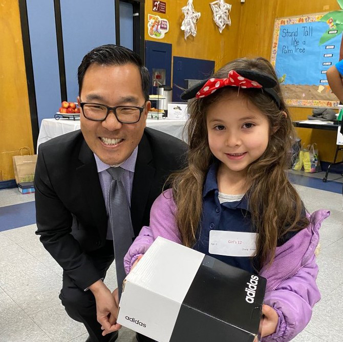 Sr. VP Eugene Cho gives shoes to kids